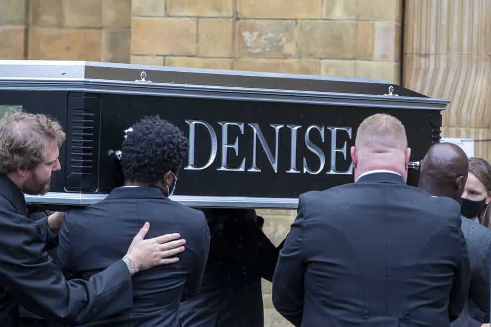 People carry the coffin outside Manchester Crematorium