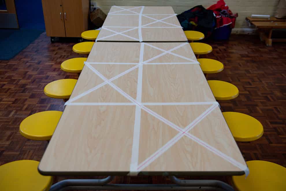 Tables are marked showing where children can sit during dinner time at a primary school (Jacob King/PA)