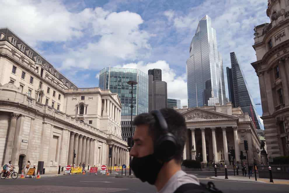 A man wearing a face mask walks past the Bank of England