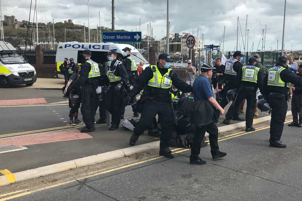 Police restrain protesters on the ground by the entrance to Dover harbour