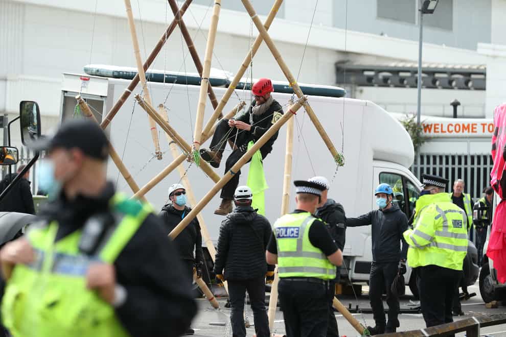 One of the protesters climbs down from the bamboo lock-ons used to block the road outside the Newsprinters printing works at Broxbourne, Hertfordshire