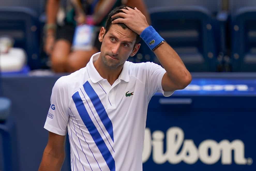 Novak Djokovic reacts after accidentally hitting a line judge with a ball