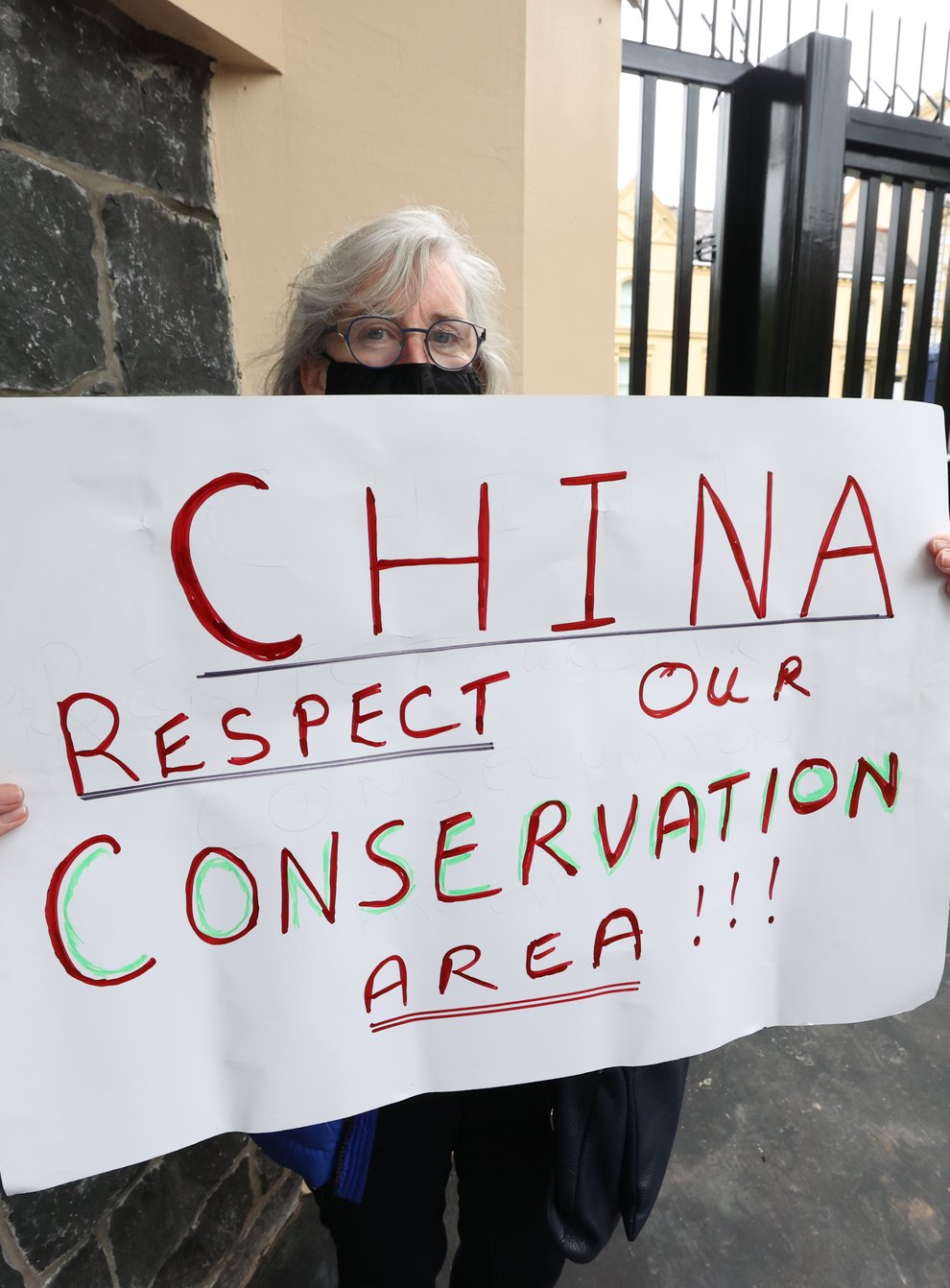 A resident protests outside the Chinese Consulate, Belfast