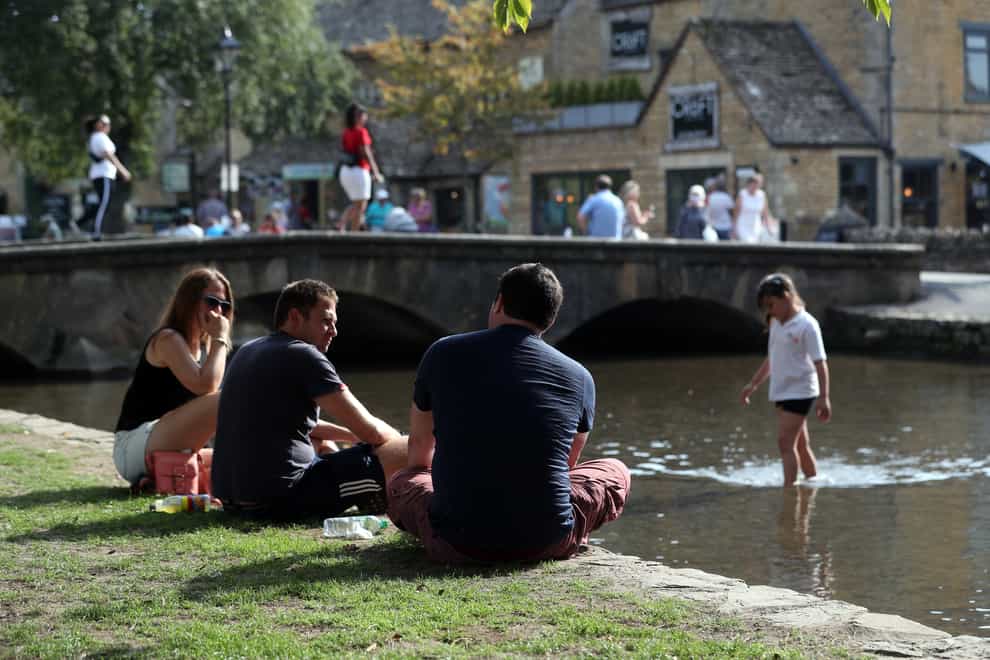 People enjoy the warm weather at Bourton-on-the-Water in the Cotswolds
