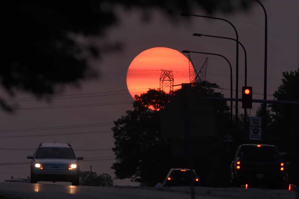 Traffic flows on Townline Road as a hazy sun sets in Vernon Hills, Illinois