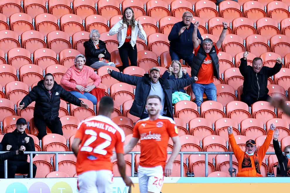 Blackpool fans celebrate from the stands after CJ Hamilton scores his first goal of the game