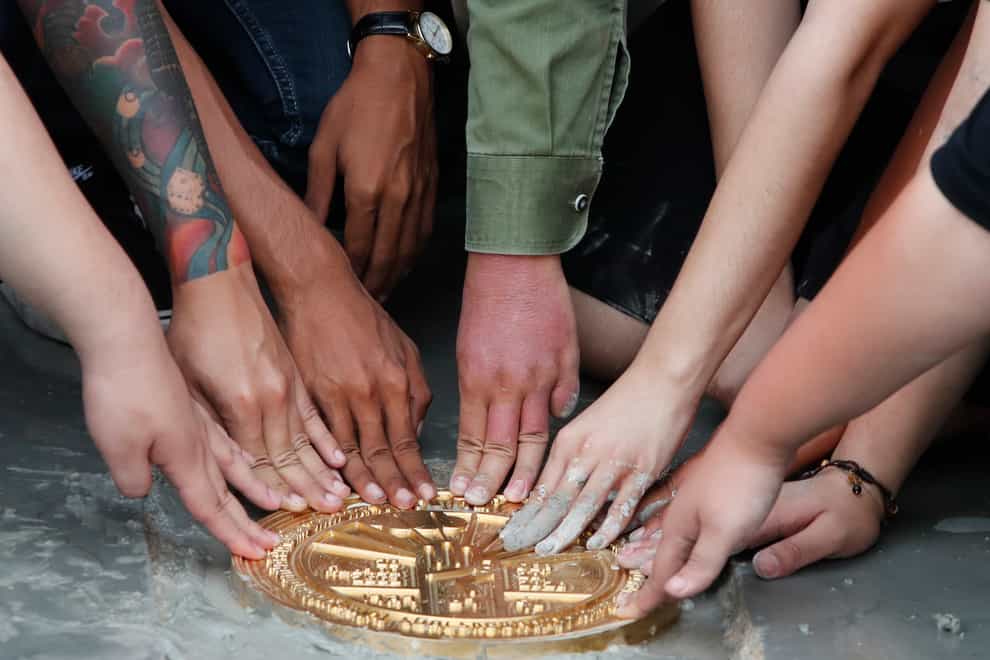 Pro-democracy student leaders install a plaque declaring 'This country belongs to the people' at the Sanam Luang field in Bangkok