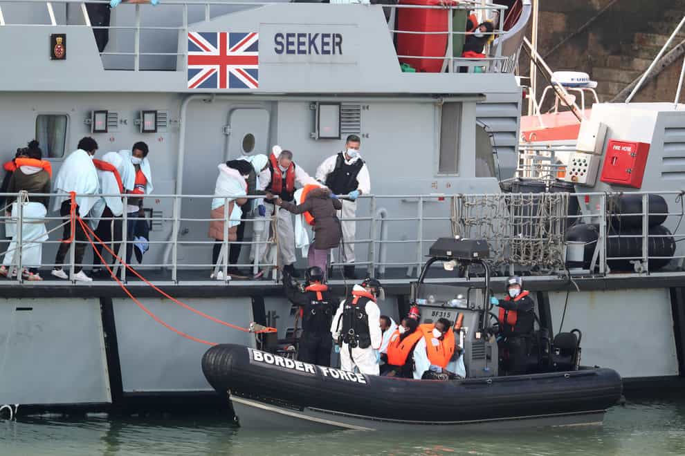 A group of people, thought to be migrants, disembark the deck of HMC Seeker at Dover marina