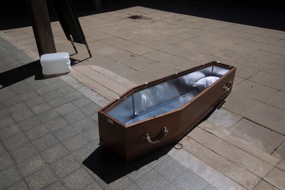 An open coffin lies on the ground at a special morgue for Covid-19 victims
