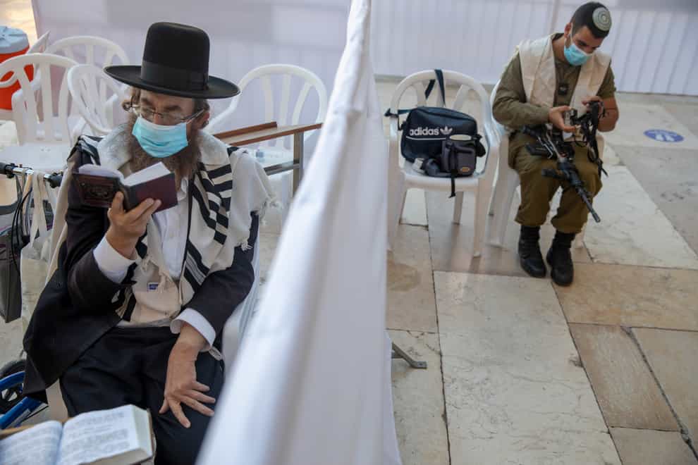 An ultra-Orthodox Jewish man and an Israeli soldier pray ahead of Yom Kippur in Jerusalem