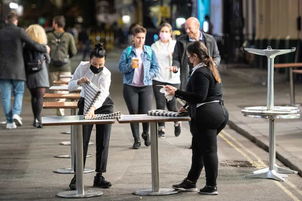 Staff clear up outside bars in Soho, London