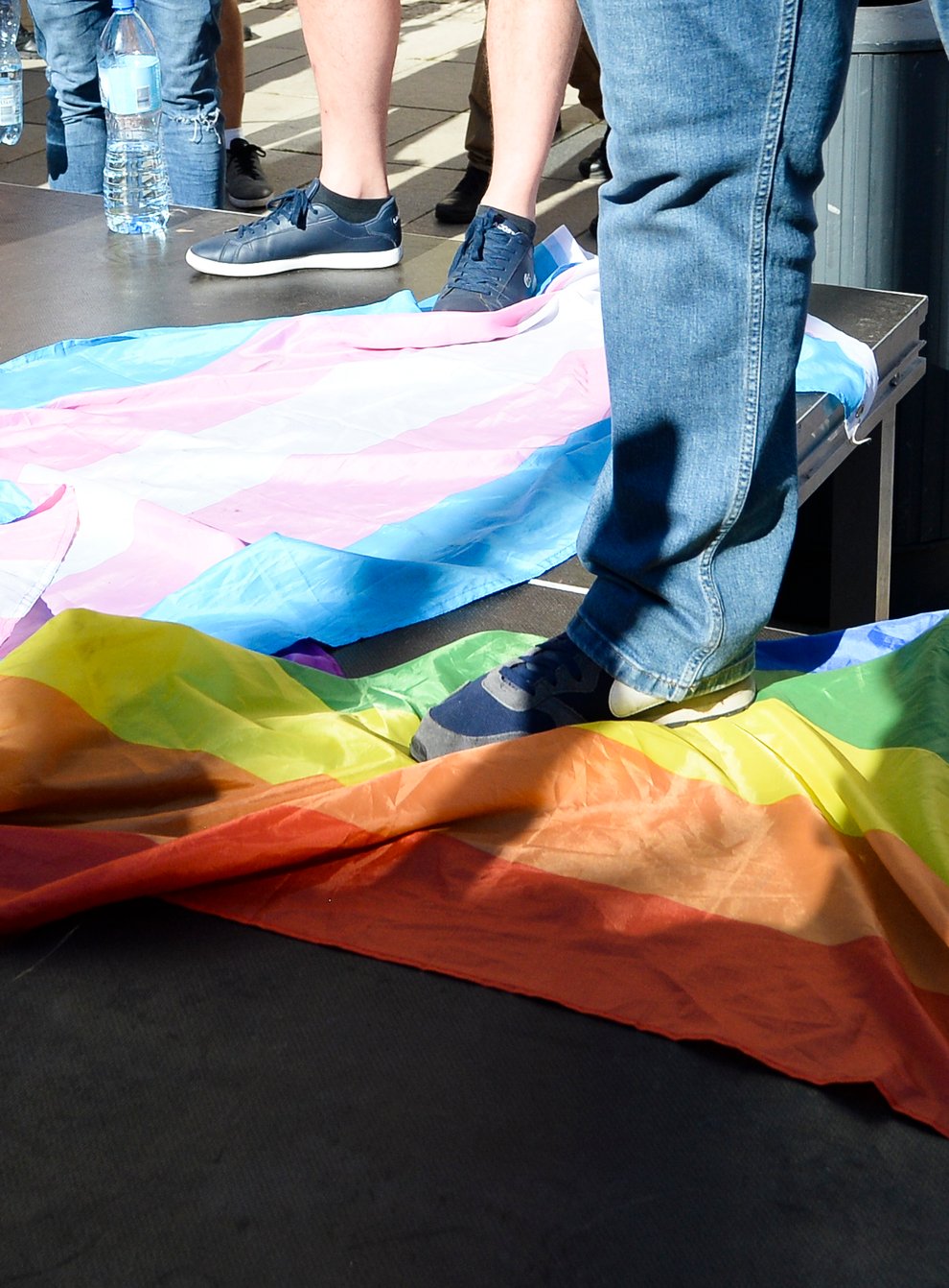 A man stands on a Rainbow Flag as he attends a demonstration of far-right activists against LGBT rights in Warsaw
