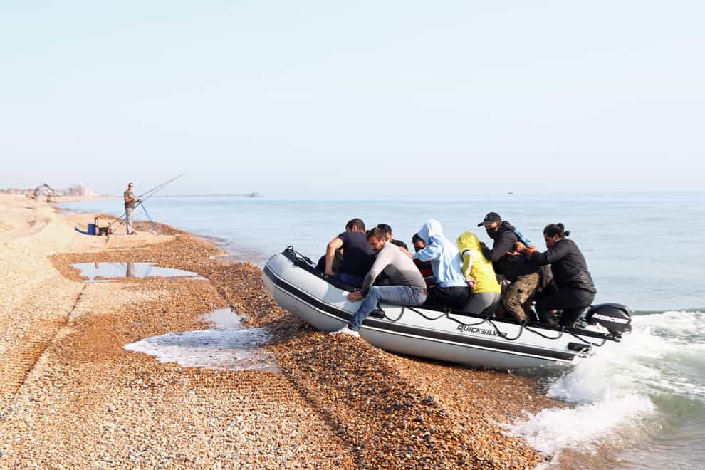 A group of people thought to be migrants arrive in an inflatable boat at Kingsdown beach, near Dover