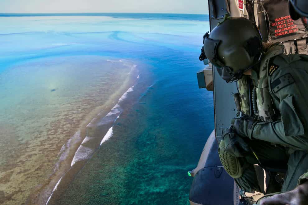 Leading Seaman Daniel Atkins looks out over Elizabeth Reef in search of unexploded ordnance