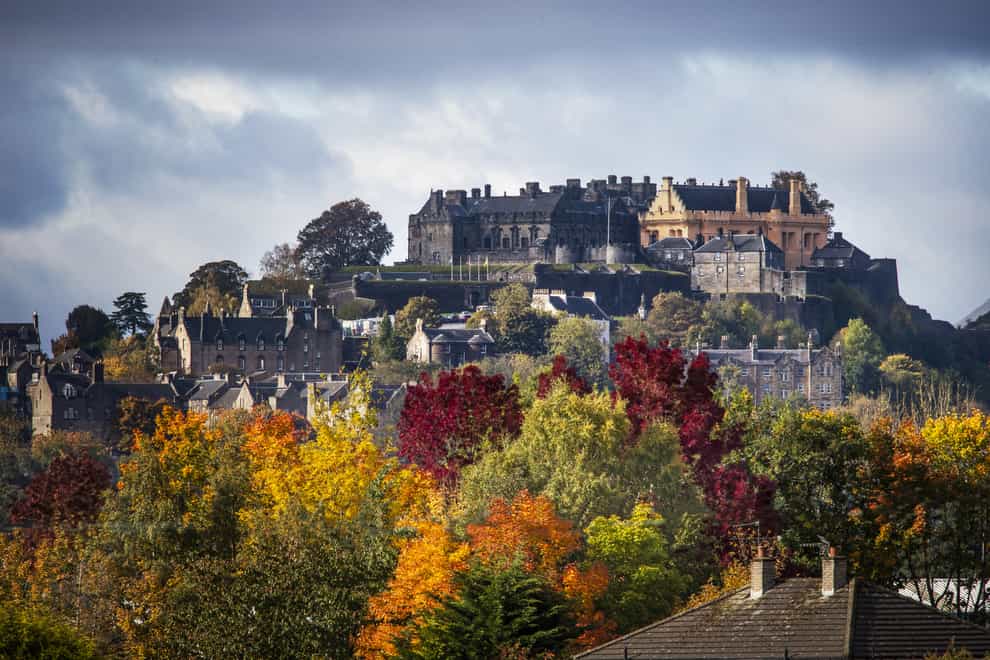 Stirling Castle surrounded by trees displaying their autumn colours