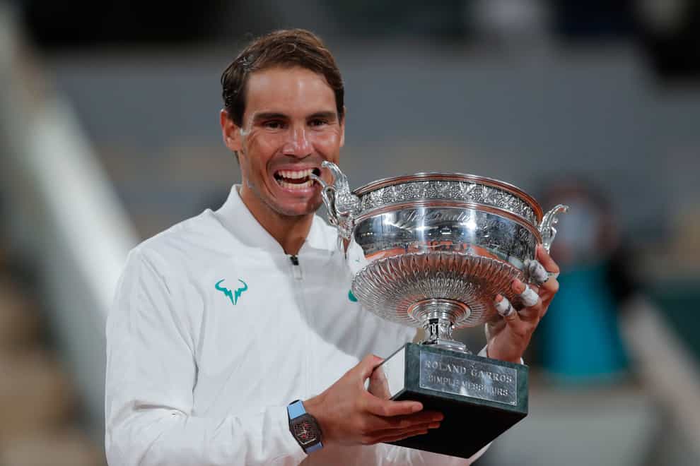 Rafael Nadal takes his customary bite of the Coupe des Mousquetaires