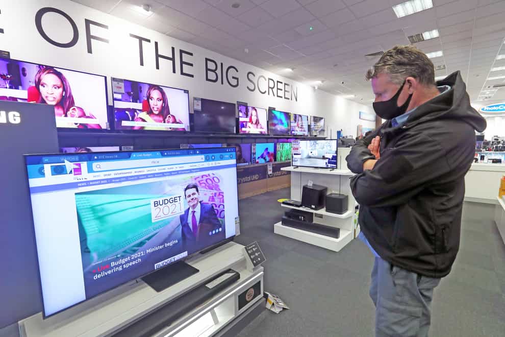 A man watches coverage of the budget on TV