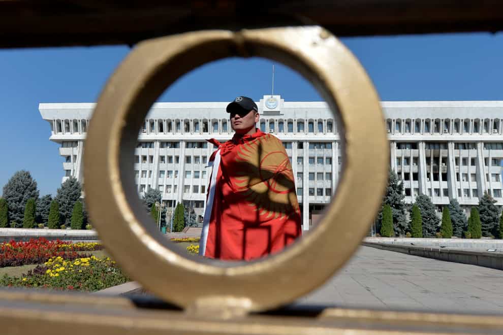 An activist stands in front of the Kyrgyz government headquarters on the central square in Bishkek (Vladimir Voronin/AP)