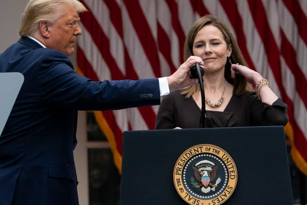 President Donald Trump adjusts the microphone after he announced Judge Amy Coney Barrett as his nominee to the Supreme Court (Alex Brandon/PA)