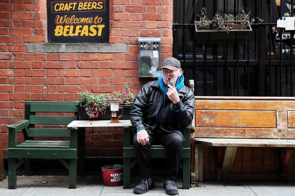 David Legge, from Belfast, enjoys a pint and a pipe outside Bittles Bar in Belfast