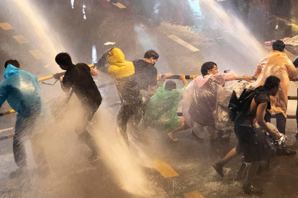 Pro-democracy demonstrators face water cannons as police try to clear the protest venue in Bangkok, Thailand (Gemunu Amarasinghe/AP)