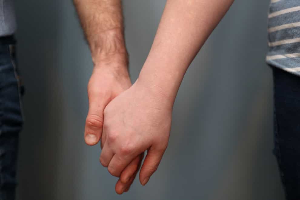 A married couple hold hands (Andrew Matthews/PA)
