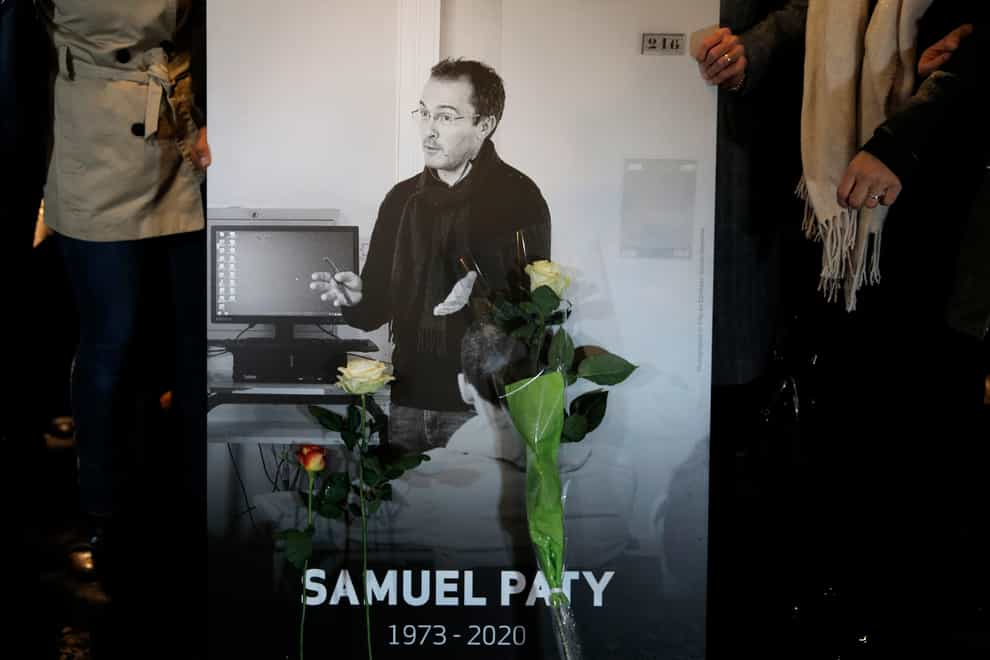 People hold a photo of the history teacher Samuel Paty