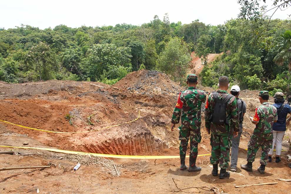 Military personnel inspect the site of a landslide at a coal mine in Muara Enim, South Sumatra