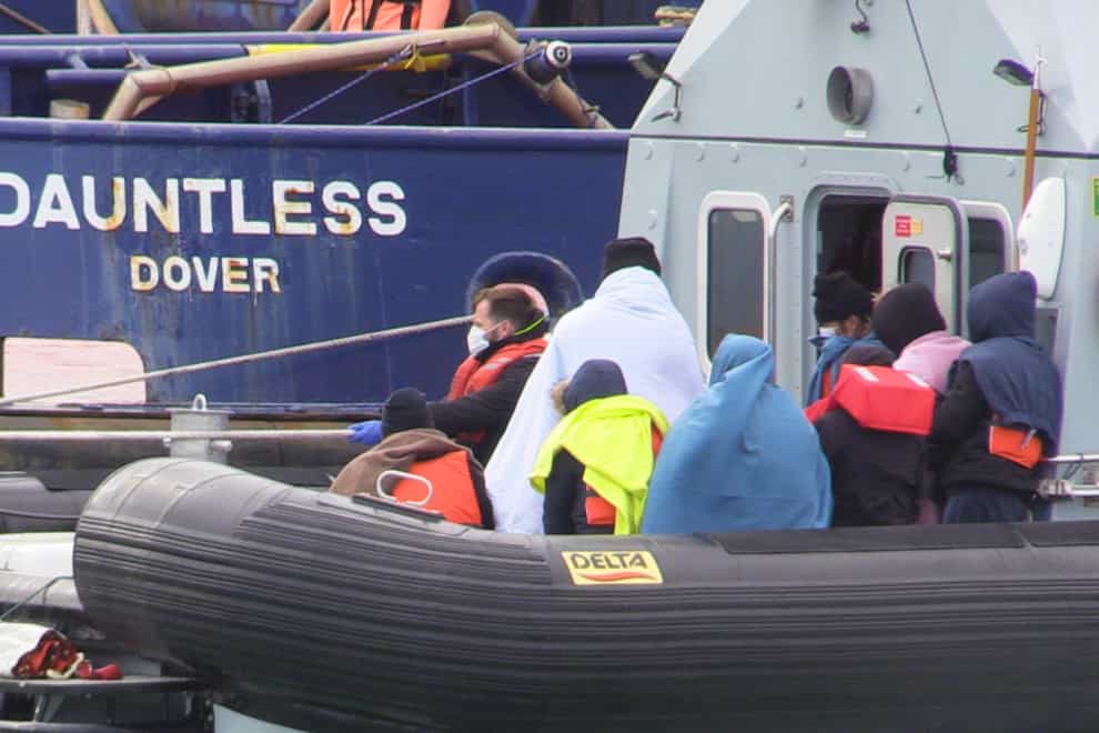 A group of people, thought to be migrants waiting to come ashore at Dover marina in Kent