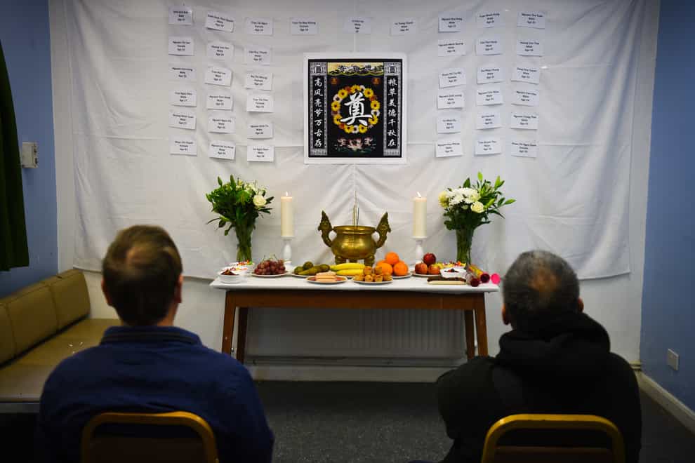 Visitors to the memorial shrine at the Hackney Chinese Community Services mark the first anniversary of the Essex container tragedy