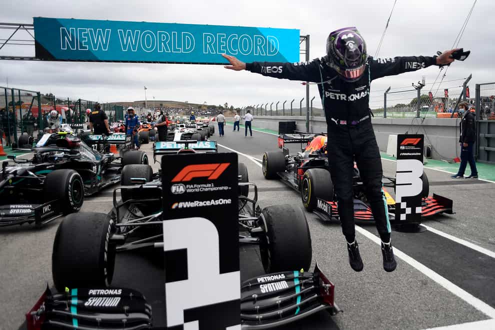 Lewis Hamilton jumps out of his car in celebration after his Portuguese Grand Prix win