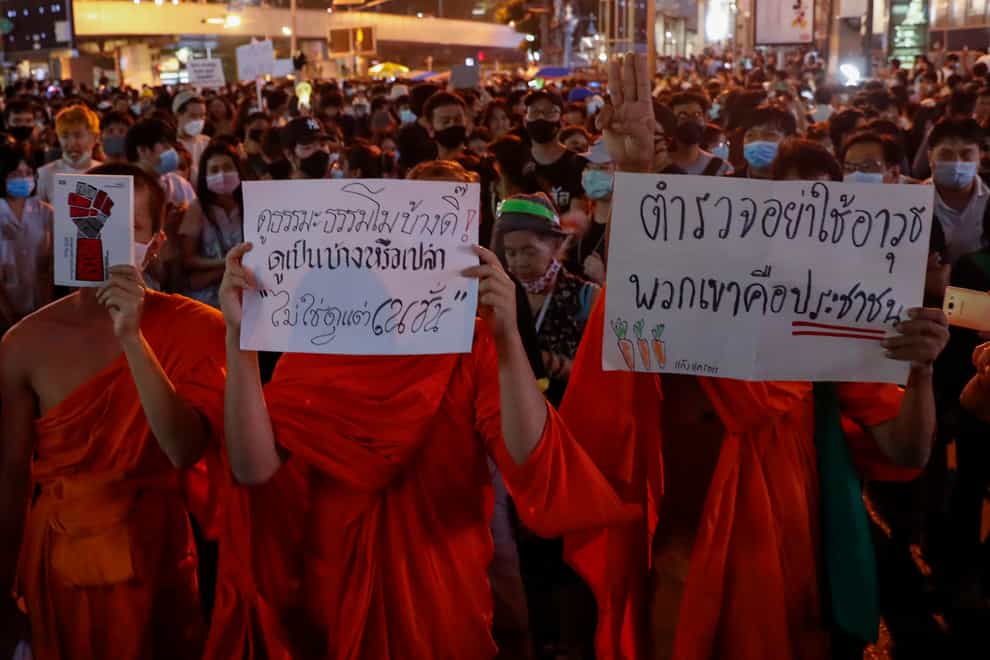 Buddhist monks supporters of pro-democracy protesters display placards as they march to the German Embassy in central Bangkok, Thailand (Gemunu Amarasinghe/AP)
