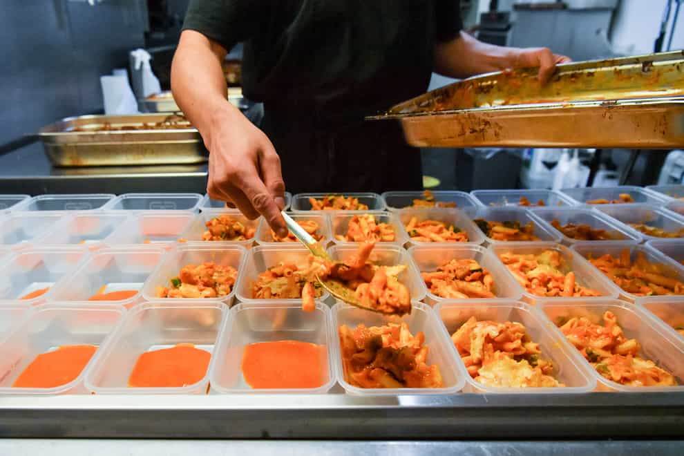 Kitchen staff prepare pasta dishes for free packed lunches