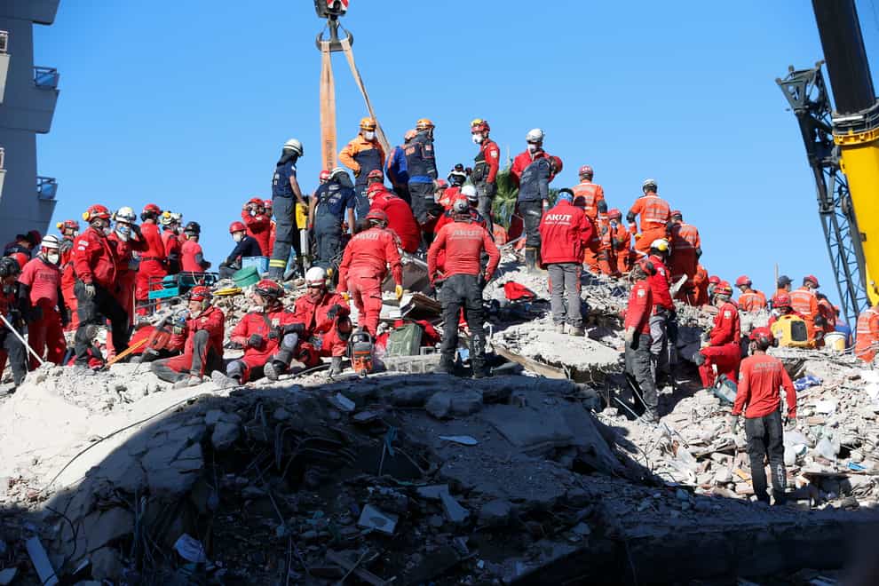 Members of rescue services search in the debris of a collapsed building for survivors in Izmir, Turkey