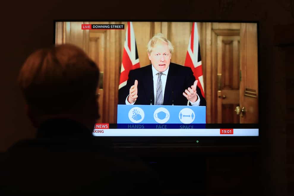 A member of the public watches Boris Johnson announcing a new England-wide lockdown (Mike Egerton/PA)