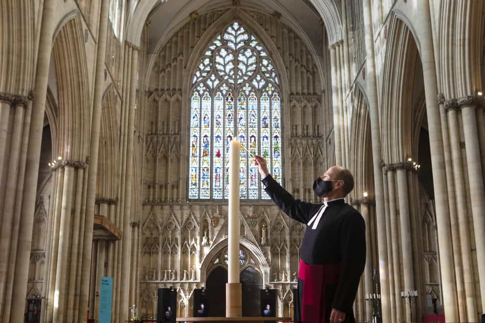 Canon Michael Smith lights a candle during York Minster’s Season of Remembrance