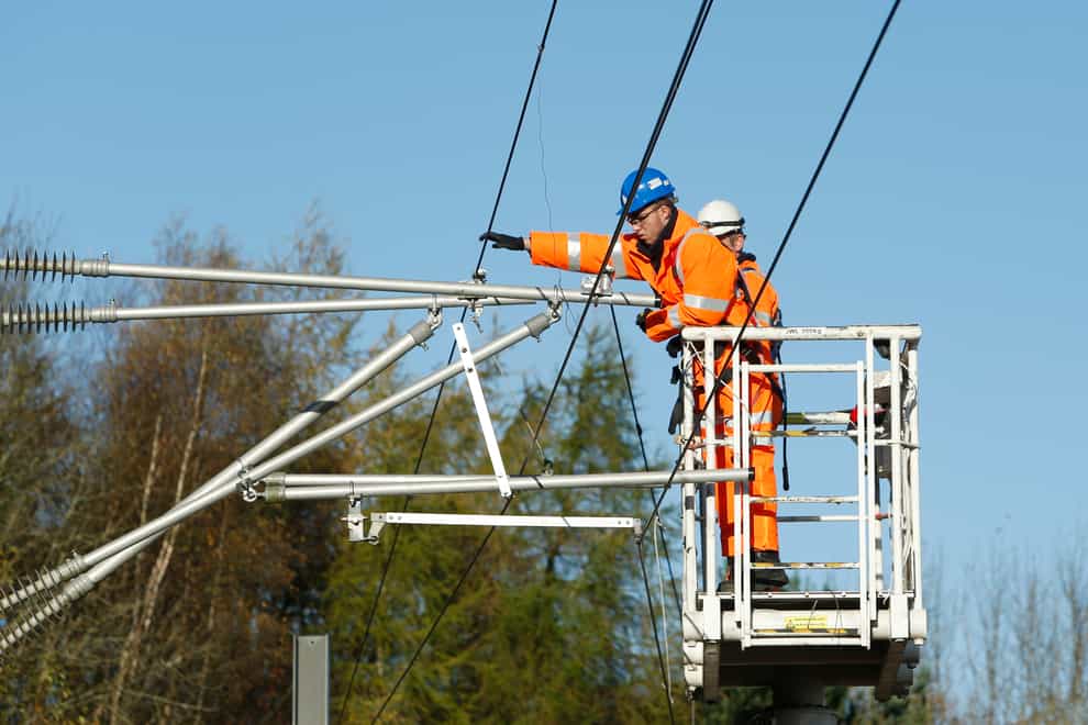 Engineers work on overhead cables