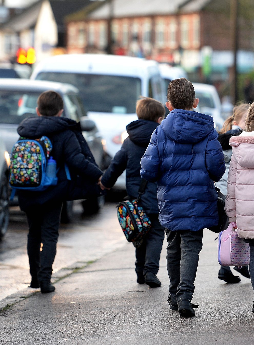 Parents walk their children to school