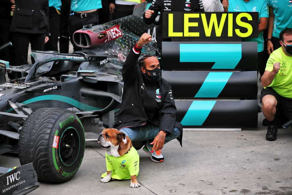 Lewis Hamilton celebrates with his dog Roscoe after winning the Turkish Grand Prix to secure a record-equalling seventh World Drivers' Championship title.