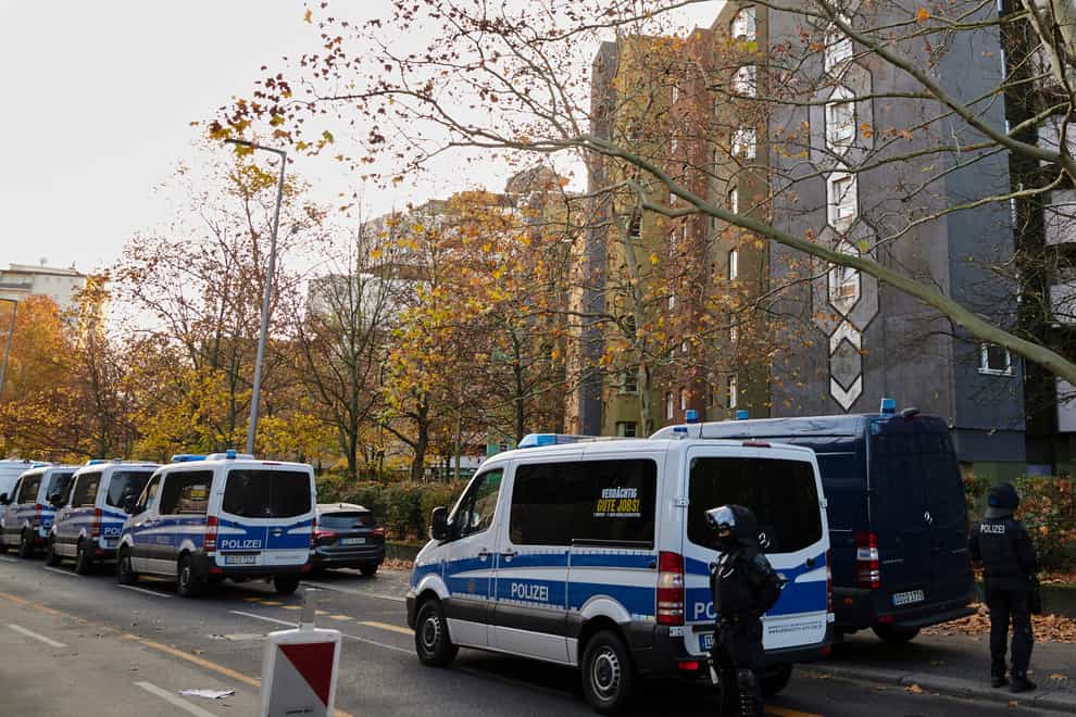 Police officers stand guard in front of an apartment building in Berlin, Germany