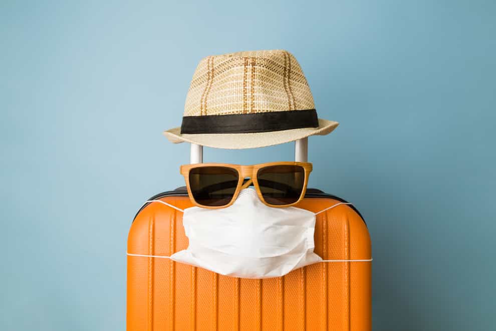 Travel restriction abstract made of tourist in form of of luggage with face mask, sunglasses and hat (iStock/PA)