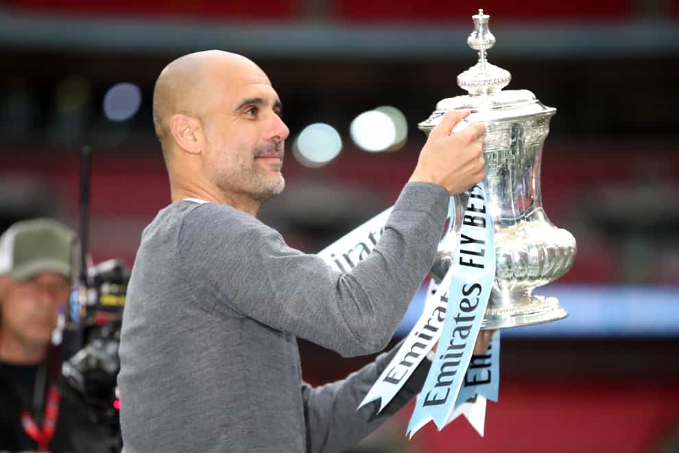 Manchester City manager Pep Guardiola celebrates with the trophy after winning the FA Cup