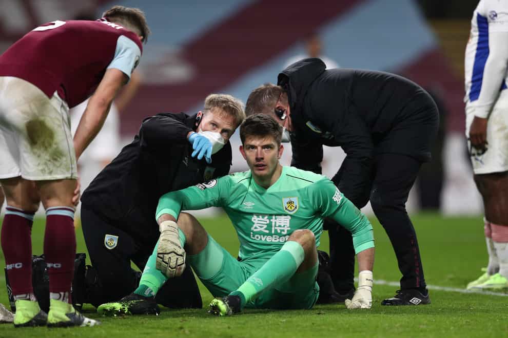 Nick Pope receives treatment after taking a knock to the head