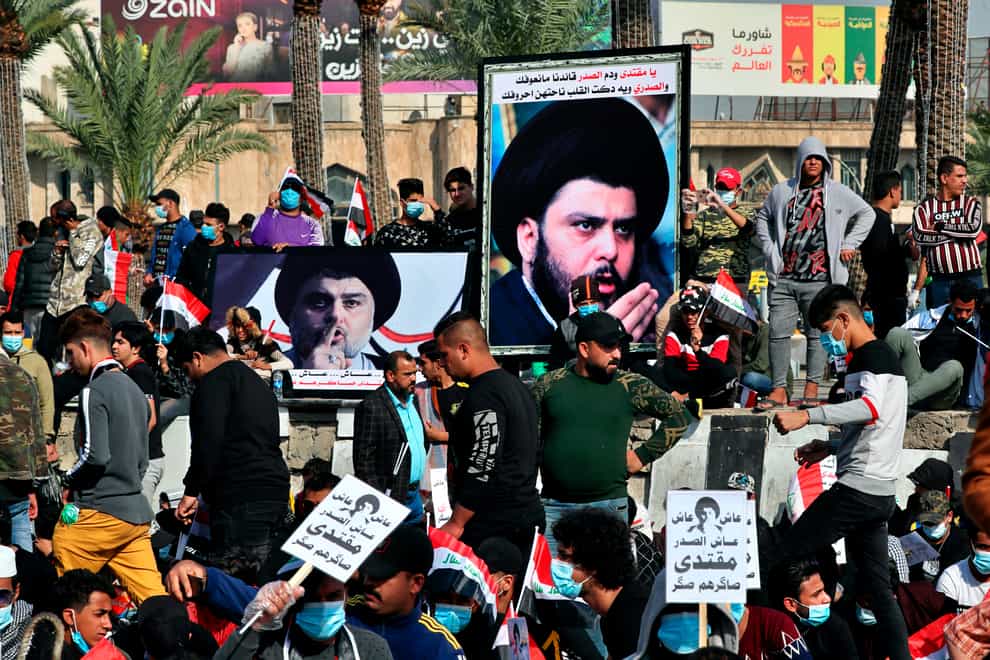 Followers of Shiite cleric Muqtada al-Sadr, in the posters, gather in Tahrir Square, Baghdad (Khalid Mohammed/AP)