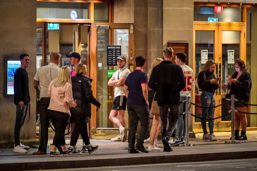 Young people queue to get into a pub in Cardiff city centre at night (Ben Birchall/PA)