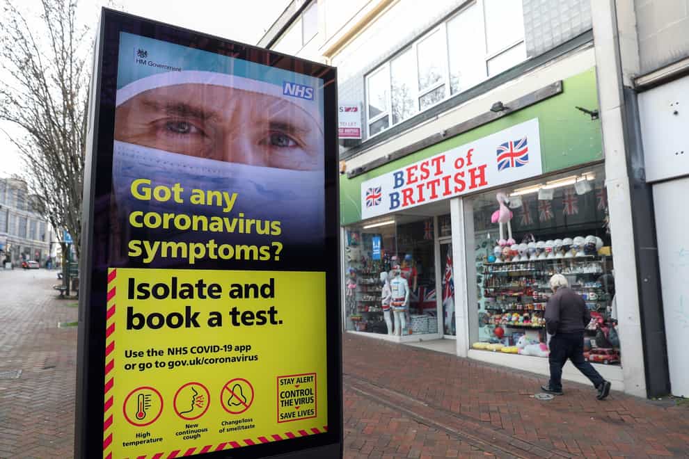 A person walks past a Government coronavirus sign on Commercial Road in Bournemouth, Dorset