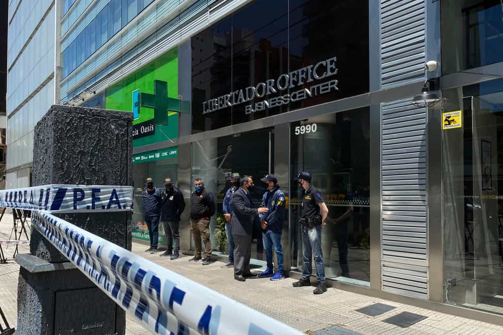 Police guard the entrance to a doctor's practice in Buenos Aires