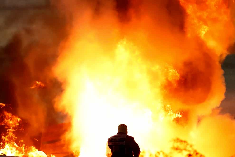 A marshal tries to extinguish the flames following Romain Grosjean's horror crash at the Bahrain Grand Prix