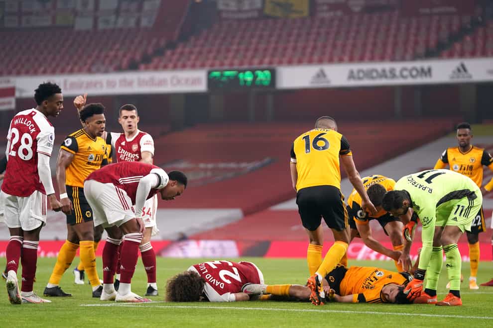 Players react after Arsenal’s David Luiz (left, floor) clashes heads with Wolves striker Raul Jimenez (right, floor) at Emirates Stadium