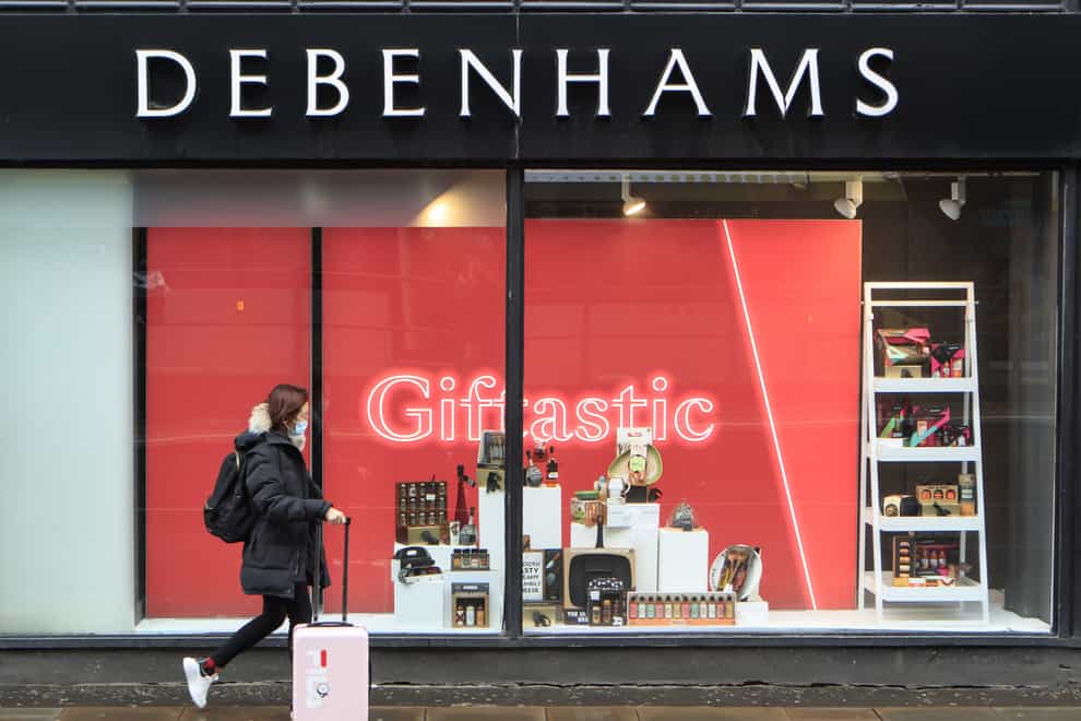 A woman walks past a Debenhams store